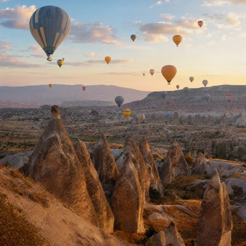 Cappadocia hot-air balloons drifting over fairy chimneys at sunrise, Turkey