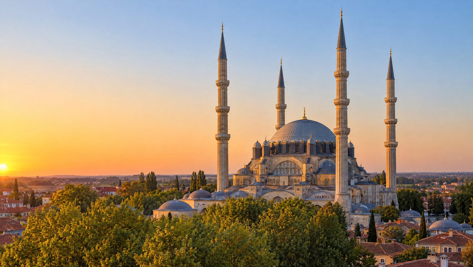 The great dome and four slender minarets of the Selimiye Mosque in Edirne rising above trees at sunset